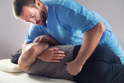 chiropractor adjusting male patients back