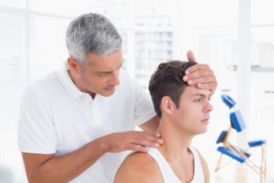 chiropractor examining patients neck